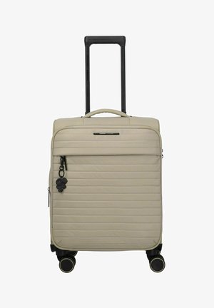 Maleta beige de soft-shell con acolchado horizontal, asa telescópica negra, bolsillo frontal con cremallera, cuatro ruedas giratorias negras y llavero negro con trébol.