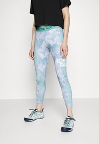 Leggings i ett ljusblått och grönt tie-dye mönster med ett robust teal midjeband som har "THE NORTH FACE" i vit text.