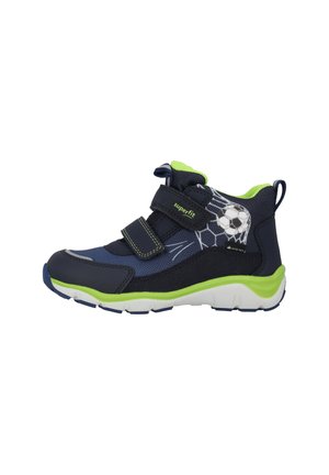 Marineblaue und grüne Kinderschuhe mit einem Fußball-Motiv, ausgestattet mit einem gepolsterten Schaft, zwei Klettverschlüssen und einer strukturierten Gummisohle.