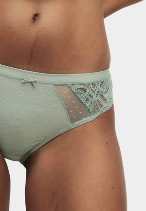 Culotte vert menthe en tissu lisse, présentant un motif à pois, une bordure en dentelle sur le côté et un petit nœud décoratif à la taille.