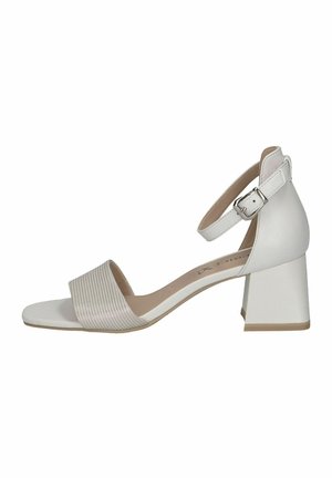 Sandal con tacco bianco dotato di una larga fascia a righe sopra le dita e di una cinghia regolabile alla caviglia. Il tacco a blocco conferisce stabilità. Texture in pelle liscia.