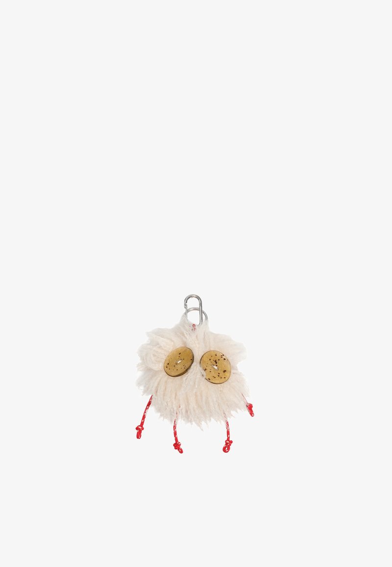 Llavero que presenta un material suave y blanco, dos botones de color marrón amarillento y acentos de cordón rojo. El diseño se asemeja a una cara caprichosa.