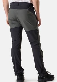 Herren Wanderhose mit einem Farbblockdesign in Dunkelgrau und Schwarz, aus leichtem Stoff gefertigt und mit Reißverschlusstaschen an den Seiten.