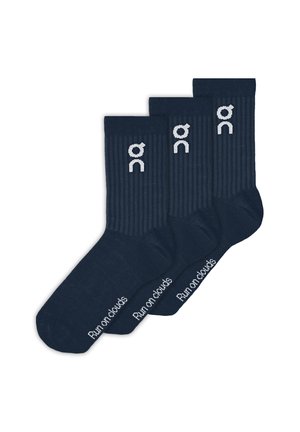 Drei Paar marineblaue gerippte Socken mit weißen "on" Logos nahe den Bündchen und dem Text "Run on clouds" auf den Sohlen.