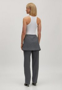 Witte geribde tanktop in combinatie met een grijze jurk tot op de knie en bijpassende grijze rechte broek, met een gladde textuur en eenvoudig ontwerp.