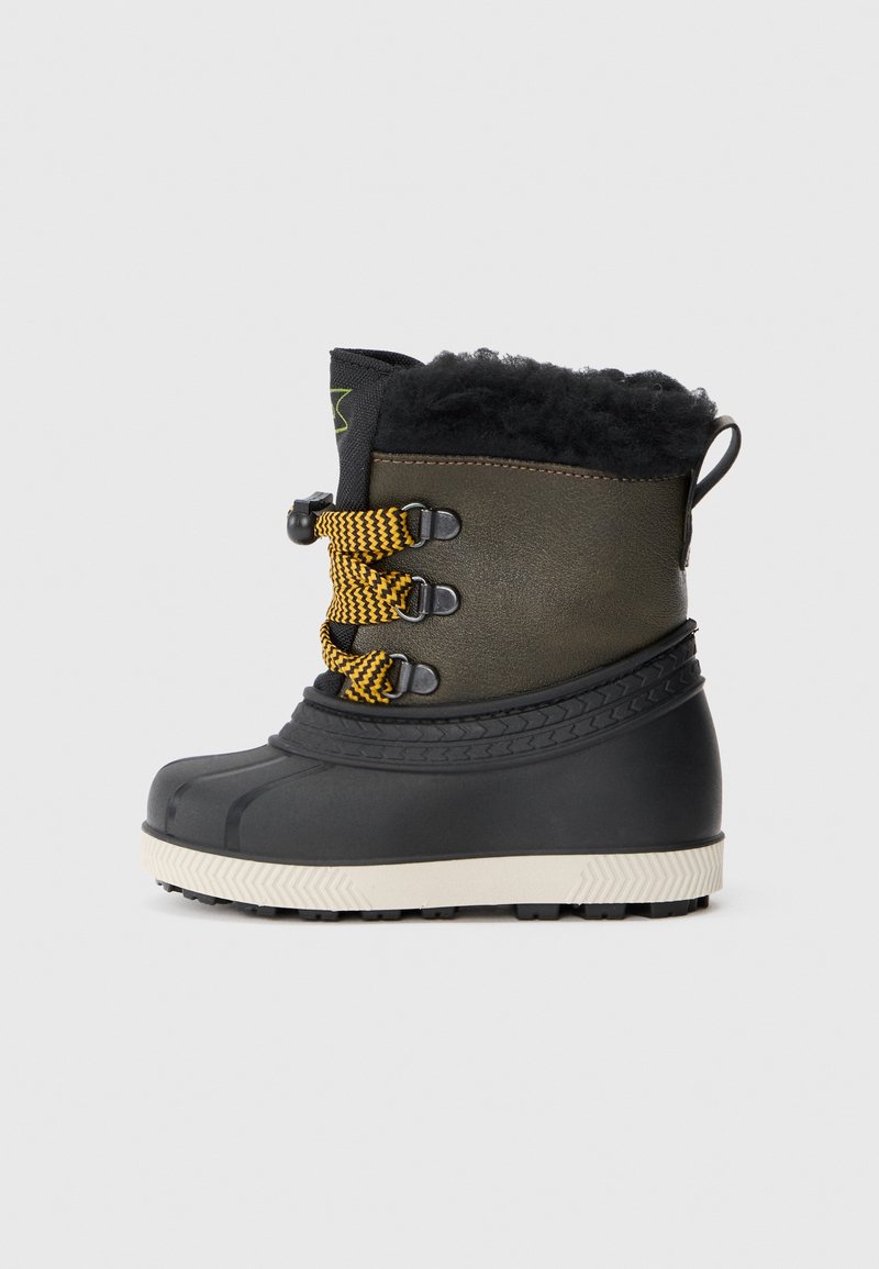 Vue latérale d'une botte d'hiver noire et olive avec des lacets jaunes et noirs, une semelle blanche et une doublure en fourrure noire en haut.