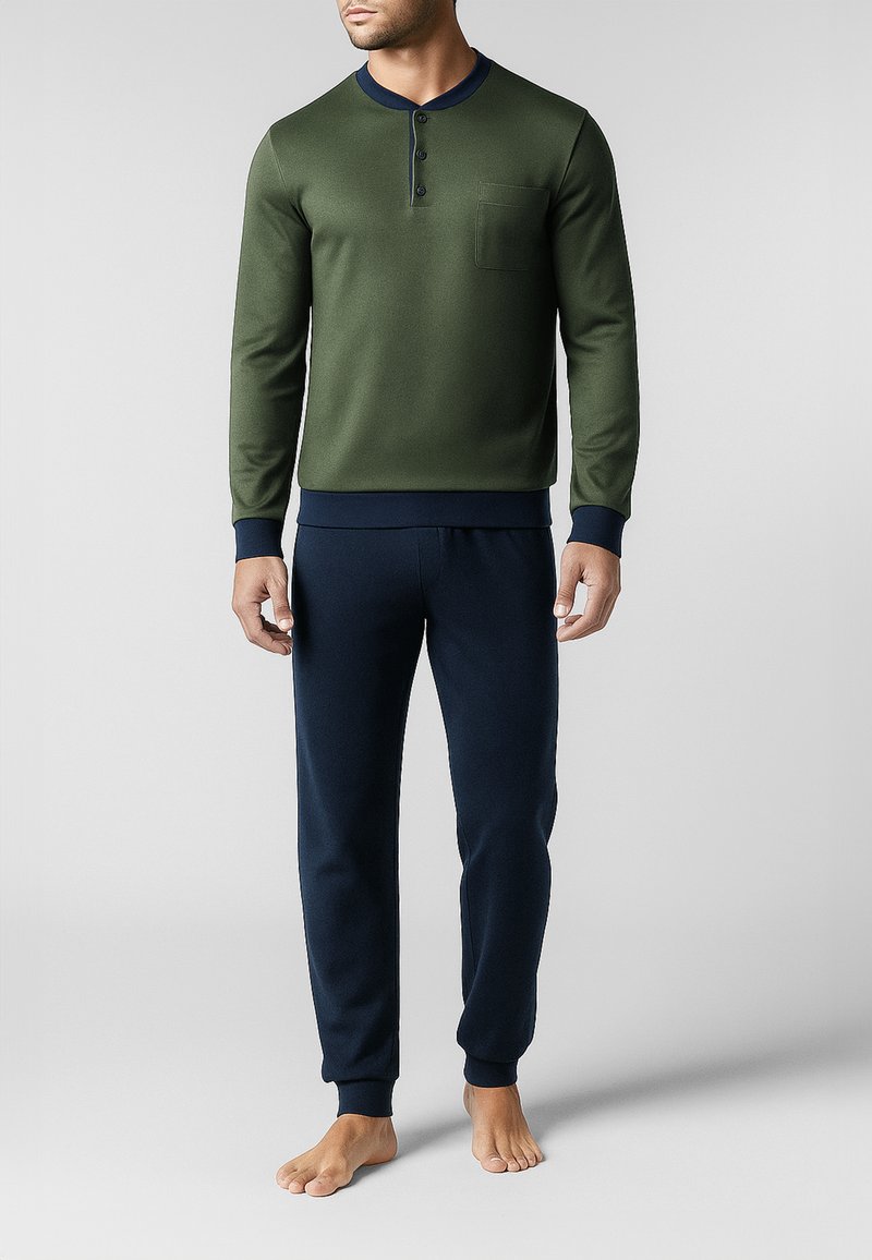 Maglietta verde a maniche lunghe con scollo rotondo, abbottonatura a tre bottoni e taschino sul petto, abbinata a pantaloni blu navy con vita elastica. Tessuto morbido.