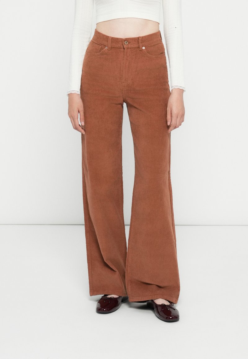 Bruine corduroy wijde broek met hoge taille, voorkeurszakken en een enkele knoopsluiting, met een gemarmerd oppervlak en rechte snit.