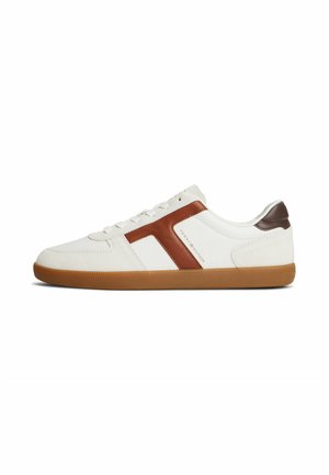 Sneaker bianca basse con banda laterale marrone e accento sul tallone, suola in gomma e lacci bianchi, con scritta Tommy Hilfiger sul lato.