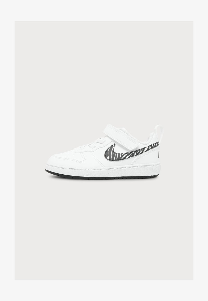 Λευκό sneaker χαμηλού ύψους με μαύρο και λευκό λογότυπο Nike σε ζεβρέ σχέδιο και κλείσιμο με αυτοκόλλητο velcro σε μονόχρωμο φόντο.