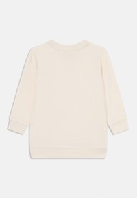 Sudadera de color crema con mangas largas, escote redondeado y puños y dobladillo acanalados. Textura suave, diseño minimalista, sin patrones visibles.
