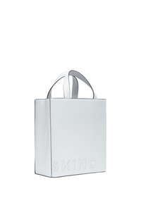 Weiße Leder-Tote-Bag mit geprägt "KIND"-Text, quadratischer Form, doppelten Griffen und kontrastierender Kantennaht. Glatte Textur, minimalistisches Design.