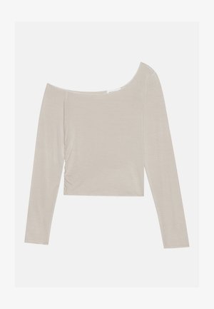 Vaalean beigekylläinen pitkähihaisia paita, jossa on olkapäälzty pois jättäävän kaula-aukon, rypistämättömyyksiä sivuilla ja pehmeä, sileä tekstuuri.