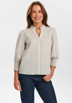 Long-sleeve blouse in cream with a floral print, featuring a mandarin collar and elastic cuffs. Smooth fabric with a relaxed fit.