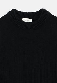 Μαύρο πλεκτό πουλόβερ με ριμπ στρογγυλή λαιμόκοψη και ετικέτα "LES DEUX" ραμμένη στο εσωτερικό του γιακά. Λείος υφασμάτινος, casual σχέδιο.