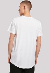 White cotton T-shirt with a round neck, short sleeves, and a slightly longer back hem. No visible patterns or graphics.