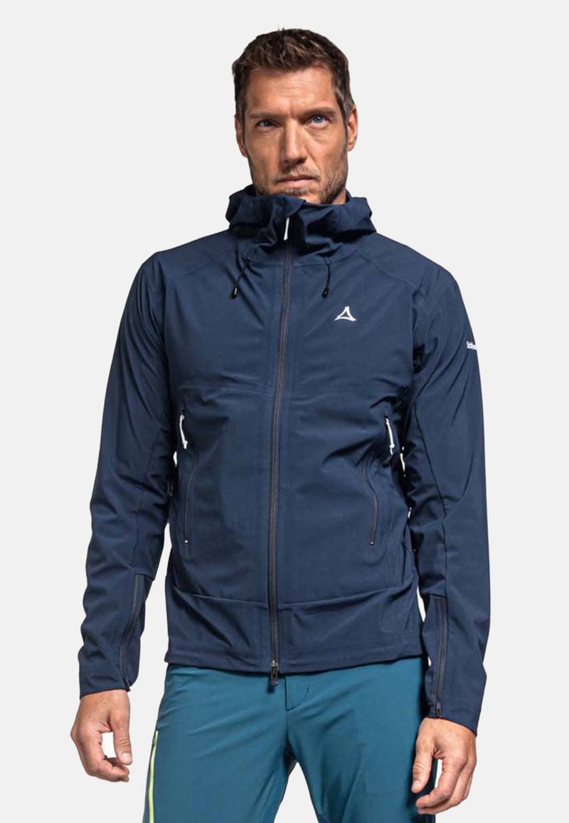 Marineblau wasserdichte Jacke mit Reißverschlusstaschen, verstellbarer Kapuze und elastischen Bündchen; zeichnet sich durch eine glatte Textur und ein minimalistisches weißes Logo aus.