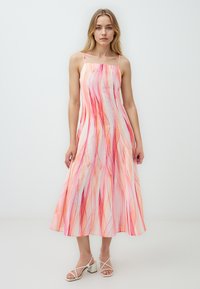 Robe maxi légère sans manches de couleur rose doux avec des motifs abstraits fluides rouges et orange. Elle présente un col carré et une coupe décontractée.