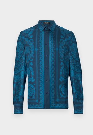 Cămașă albastră cu mâneci lungi, cu modele complexe florale și geometrice, cu nasturi în față și guler structurat. Material texturat.