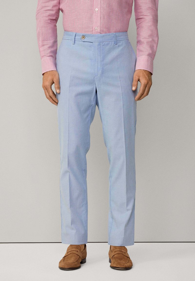 Jasnoniebieskie spodnie w paski wykonane z gładkiego materiału, charakteryzujące się prostym krojem, jedynym zapięciem na guzik oraz bocznymi kieszeniami.