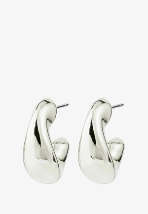 Srebrne metalne naušnice s uvijenim, skulpturalnim dizajnom. Glatka, polirana površina sa sjajnim završetkom. Igle na kopču za sigurno nošenje.