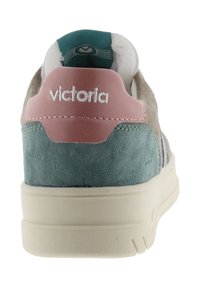 Zapatilla con una parte superior de ante beige, talón de ante turquesa y cuello de cuero rosa. Presenta costuras blancas y un logo en la parte trasera.