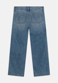 Jeans de mezclilla azul de pierna ancha, con cintura de media altura, dos bolsillos traseros, dobladillo sin terminar, textura desgastada y detalle de costura en contraste.