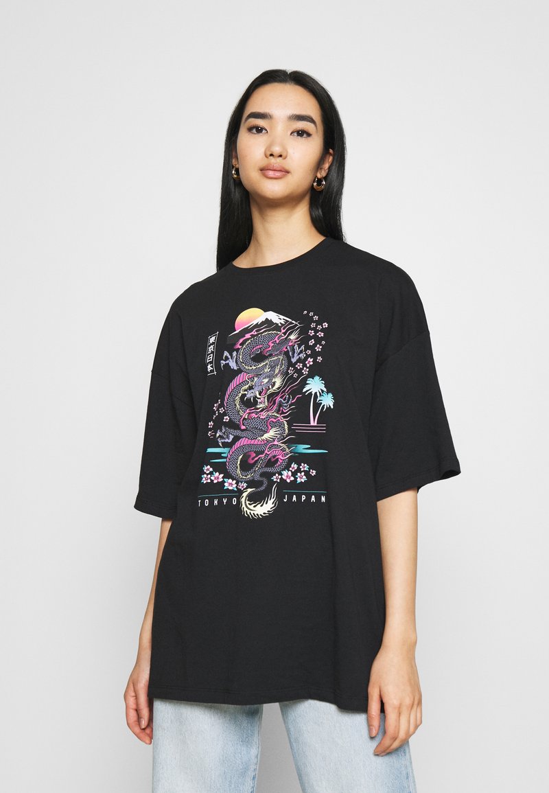 Svart oversized t-skjorte med et fargerikt dragegrafikk med kirsebærblomster og solnedgang, laget av bomull med en avslappet passform.