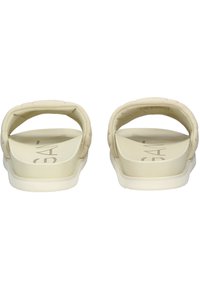 Beige slide sandaler med en tekstureret overdel, åben tå-design og en polstret rem. Har en flad hvid sål og et diskret logo på indersålen.