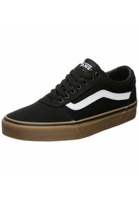 Zapatillas de lona negras con una franja lateral blanca, cordones negros y suela de goma marrón. Presentan una puntera redonda y detalles de costura.