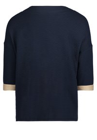 Marinblå randskjorta med korta ärmar, med guldaccenter vid ärmsluten. Mjuk textur och avslappnad passform, lämplig för vardagsbruk.