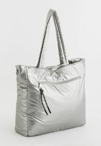 Srebrna nylonowa torba na ramię z pikowanym wzorem, z podwójnymi uchwytami i przednią kieszenią na zamek błyskawiczny, wyposażoną w kolorowy pleciony uchwyt.