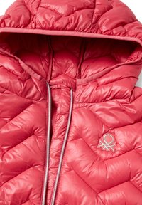 Red puffy jacket featuring a hood, zigzag quilted pattern, and a silver zipper. Includes a small embroidered logo on the chest.