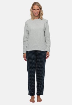 Grå långärmad topp och marinblå byxor med prickar. Tyget ser mjukt ut, med en avslappnad passform och en enkel design. Hudton synlig på bara fötter.