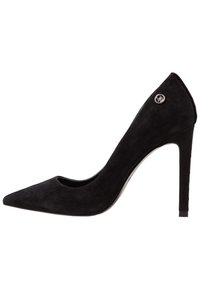 Zapato de tacón alto de ante negro con puntera puntiaguda y un lado abierto. Presenta un acabado brillante con un acento de logo plateado en el tacón. Textura suave.
