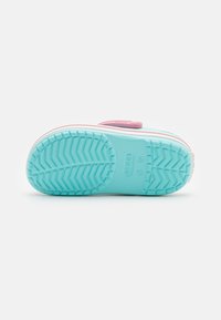 Light blue rubber shoe sole with a textured tread pattern, pink accents, and a white rim. Inscription and logo visible on the sole.