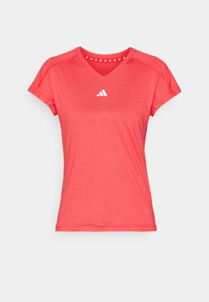 Piros sportpóló rövid ujjakkal, V-nyakkal, fehér logóval a mellkason. Simogató, könnyű anyagból készült.