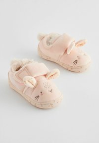 Chaussons en peluche rose pour enfants avec un design de visage de lapin, présentant des oreilles tombantes et des accents en pom-pom. Doublure intérieure douce et semelle texturée.