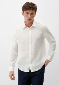 Weißes langärmliges Hemd mit Knöpfen aus leichtem Stoff, mit klassischem Kragen, strukturiertem Gewebe und abgerundetem Saum. Trägt man mit marineblauen Hosen.