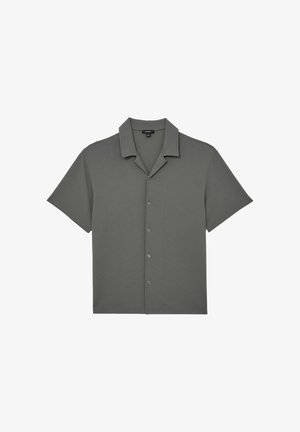 Siva košulja s kratkim rukavima s kopčanjem na dugmad i kamp ovratnikom, izrađena od teksturiranog tkanja, položena ravno na bijeloj podlozi.