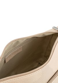 Beige Lederhandtasche mit strukturierter Oberfläche, Reißverschluss und beigem Innenfutter aus Stoff mit einem kleinen Etikett.