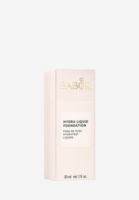 Emballage du fond de teint liquide Babor Hydra, boîte rose pâle avec des lignes horizontales texturées, logo doré et étiquette avec le nom du produit clair, 30 ml.