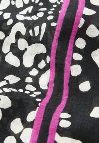 Tessuto nero con un audace motivo astratto caratterizzato da forme bianche irregolari e due strisce rosa parallele che scorrono verticalmente. Leggera texture.