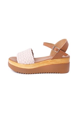 Sandali in pelle rosa intrecciata con una cinghia alla caviglia marrone e una suola in legno spessa con texture a zigzag.