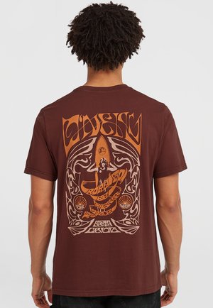 Bruine katoenen T-shirt met een grote oranje en beige grafische afbeelding op de achterkant, die een surfer en ingewikkelde patronen afbeeldt.