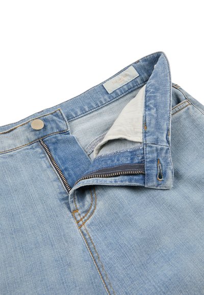 Jeans in denim azzurro chiaro con cerniera aperta e bottone in metallo, che mostrano la vita e la fodera interna della tasca.