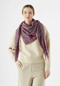 Grand foulard triangulaire en imprimé léopard rose et gris, tissu texturé, avec un détail de couture contrasté. Porté autour du cou.