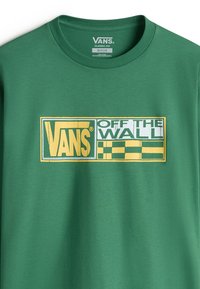 Grünes Baumwoll-T-Shirt mit einem großen gelb-weißen "VANS OFF THE WALL" Logo und karierten Akzenten, klassischer Schnitt, Rundhalsausschnitt.