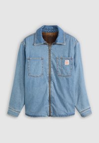 Chaqueta de mezclilla en azul claro con mangas largas, cremallera frontal, dos bolsillos en el pecho y un forro texturizado marrón. Presenta costuras en contraste.