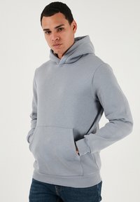 Világosszürke kapucnis pulóver puha, texturált anyagból, kenguru zsebbel, állítható kapucnival és bordázott mandzsettával. Klasszikus szabású, alkalmas hétköznapi viseletre.